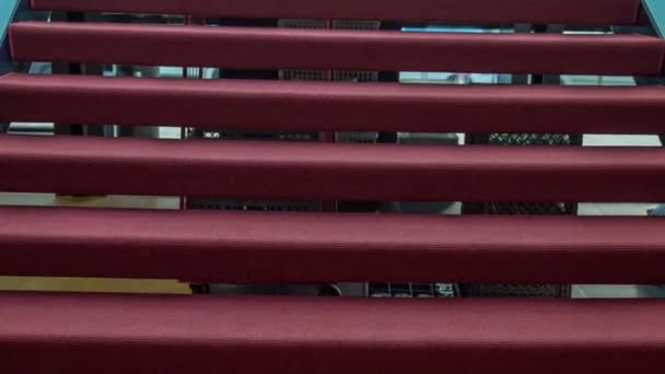 アートギャラリーの内部に保護ガラスフェンスとレッドカーペットフローリングの近代的な階段 — ストック動画