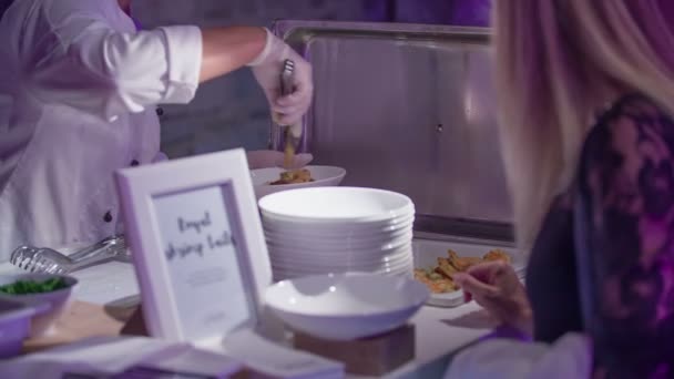 身穿白色制服的年轻厨师助理慢慢地把虾的尾巴放在白盘子上 然后把它给一个可爱的女客人 — 图库视频影像