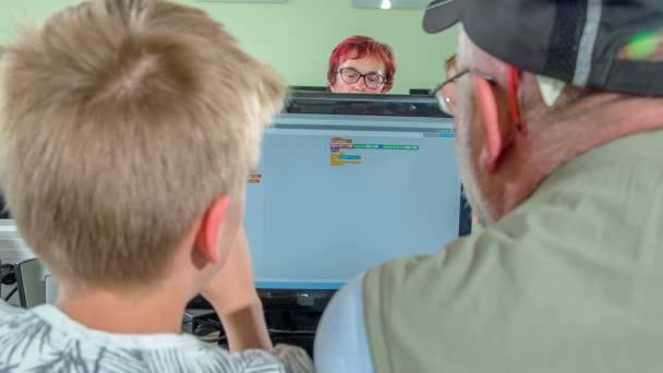 年轻和年长的一代正在小学里一起学习电脑 这是一个很好的例子 年轻一代如何帮助老一辈 — 图库视频影像