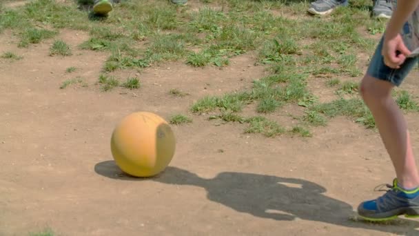 少年の一人がボールを蹴っている 男の子は遊び場で学校の外でサッカーをしています — ストック動画