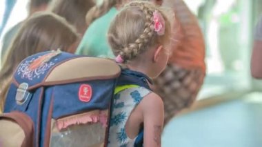 Çocuklar soyunma odasında ayakkabılarını çıkarıp terlik giyiyorlar..