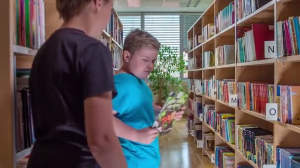 Dos Rapazes Mostra Colega Que Prateleira Deve Devolver Livro Numa — Vídeo de Stock