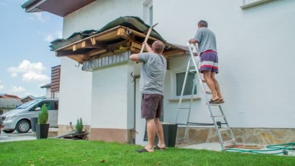 Joven Derribando Techo Con Pico Anciano Hombre Está Subiendo Escalera — Vídeo de stock