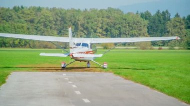 Küçük bir uçak pist olarak kullanılan çimlerin üzerinde gider ve kalkış için gerekli hıza ulaşmak için hızlanmaya başlar..