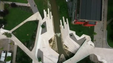 Slovenya 'nın Velenje kentindeki derenin üzerindeki modern ve alışılmadık köprü kuş bakışı..