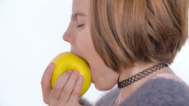 Een Jong Meisje Eet Een Grote Gele Appel — Stockvideo