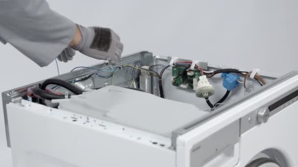 現代の洗濯機に挿入されている電子回路にケーブルを慎重に接続する専門的なメンテナンスマン — ストック動画
