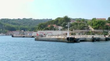 Bir liman ve küçük bir deniz kasabası görebiliyoruz. Güneş parlıyor ve güzel bir yaz günü olacağa benziyor..
