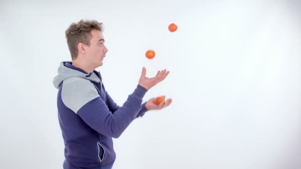 Ein Junger Mann Jongliert Mit Mandarinen — Stockvideo