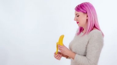 Yavaşça bir muz soyma ve sonra içine ısırma. Yan görünüm.