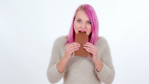 Una Joven Está Mordiendo Gran Chocolate Con Leche — Vídeo de stock