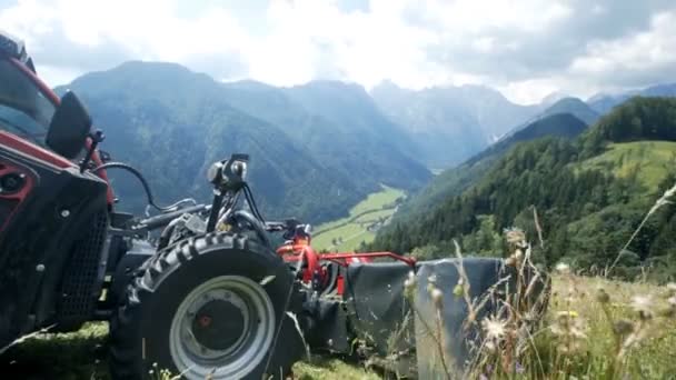 Een Boer Rijdt Langzaam Zijn Tractor Bergafwaarts Wanneer Hij Gras — Stockvideo