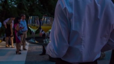 Garson elinde bir tepsi şampanyayla barın yanında duruyor.