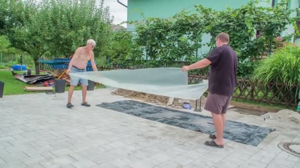 Homens Cuidadosamente Colocando Folha Plástico Transparente Para Blocos Pavimentação Para — Vídeo de Stock
