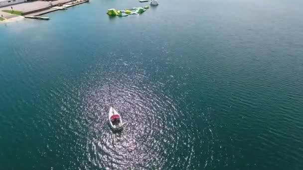 背景に中央のビーチとスロベニアの湖Velenjeに停泊帆船 — ストック動画