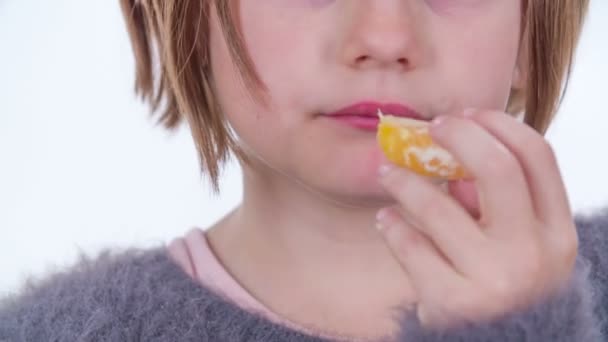 一个小女孩尝着橘子的味道 她觉得它们很酸 — 图库视频影像