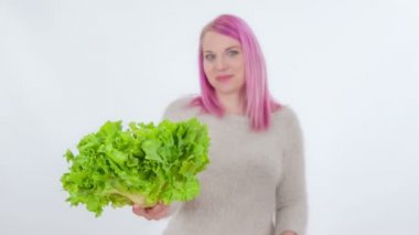 Genç bir kadın elindeki çiğ marulu yiyor..