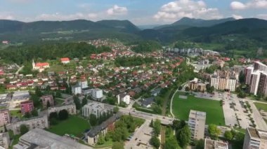 Slovenya 'nın Velenje şehrinde tepelerle çevrili bir sürü apartman dairesi var..