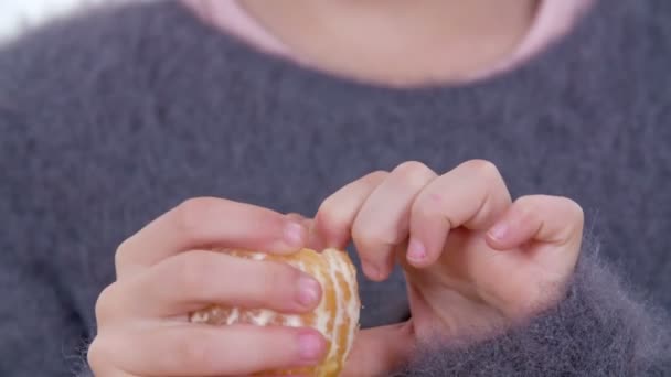 Una Chica Está Comiendo Una Mandarina Ella Está Tomando Rebanada — Vídeos de Stock