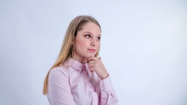 A young woman who has beautiful make up on is thinking about something and then suddenly she gets an idea.