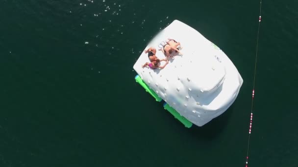 Grupo Jóvenes Disfrutando Subiendo Inflable Flotante Saltando Lago — Vídeos de Stock