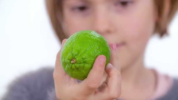 Młoda Dziewczyna Patrzy Zieloną Limonkę Dłoni — Wideo stockowe