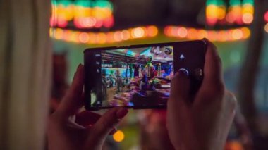 Bir kadın, dönmedolambaçlı yolda giden çocukları kaydediyor.