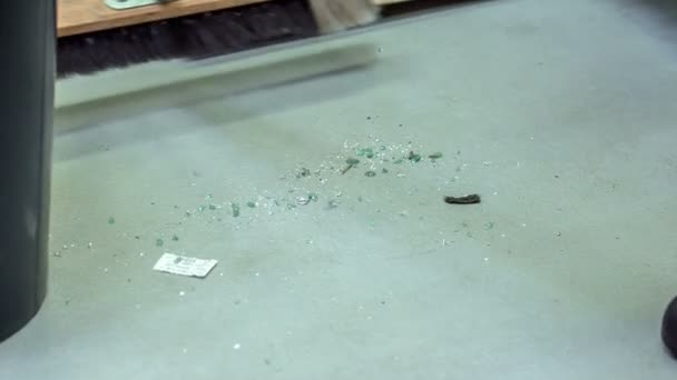 ガラスが割れていたので 男が大きなほうきで床を掃いている これは車の修理店で行われています — ストック動画