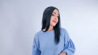 Genç bir kadının güzel bir makyajı vardır. O göz kırpıyor ve kamera önünde poz veriyor.