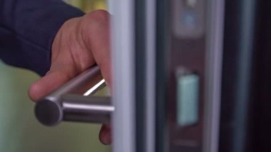 Dükkandaki lüks kapıyı test eden adamın yakın çekim görüntüleri.