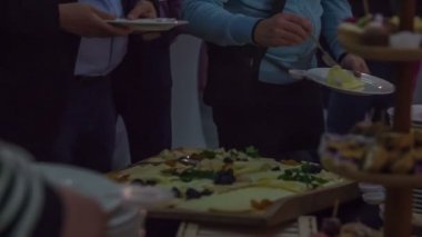 Zalec, Slovenya - 1. Aralık 2017 Misafirler yemek büfesinden yemek alıyor ve tabaklarına koyuyorlar. Oda karanlık..