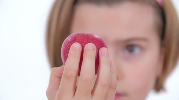 若い女の子は小さな赤い有機リンゴを食べている — ストック動画