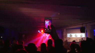 Zalec, Slovenya - 1. Aralık 2017 Sahnede sahne alan bir şarkıcının cep telefonuyla etkinlik kayıtlarında bir ziyaretçi.