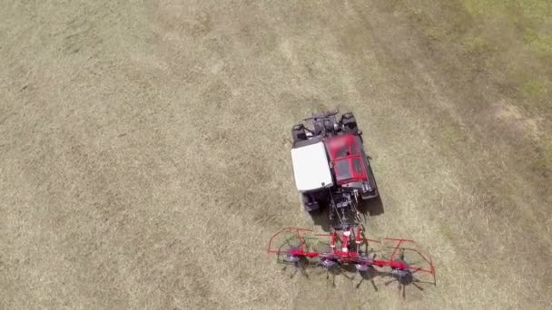 巨大なトラクターは その背後に農業機械を引っ張っていると干し草を準備しています 夏の時間だ空中射撃 — ストック動画
