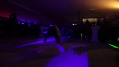 Zalec, Slovenya - 1. Aralık 2017 Seyirci önünde kulüpte bir break dansçı serbest stil. Onu sahne izlerken birçok kişi var ve kalabalık alkışlıyor. Bir ışık gösterisi var..