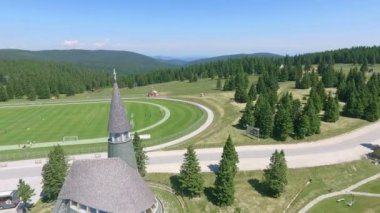 Farklı spor aktiviteleri için büyük yeşil bir saha. Güneşli bir yaz günü. Bu tatil beldesi kışın harika bir kayak merkezi olabilir..