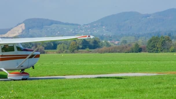 一架白色和橙色的小飞机开始在跑道上驾驶 准备起飞 今天天气很好 — 图库视频影像