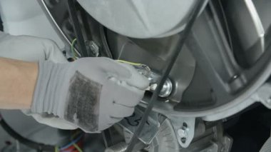 Tamirci profesyonel olarak ısıtıcıya elektrik sağlayan elektrik kablolarını söker..