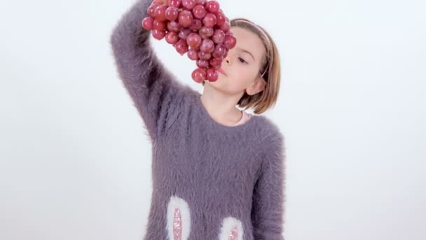 Ein Kleines Mädchen Isst Große Rote Trauben Von Unten — Stockvideo