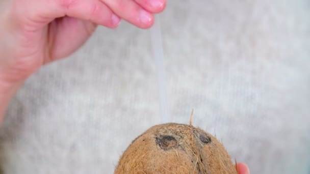 この若い女は藁をココナッツに入れて飲んでる — ストック動画