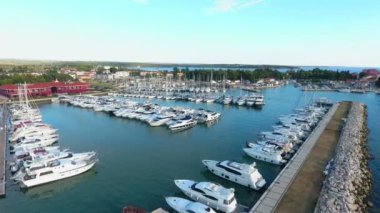 Bir sürü yat ve yelkenli tekne marinada park halinde.