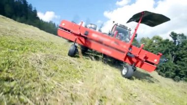 Tırmıklar tarım makinelerinde hareket ederken saman sola ve sağa doğru uçuyor..