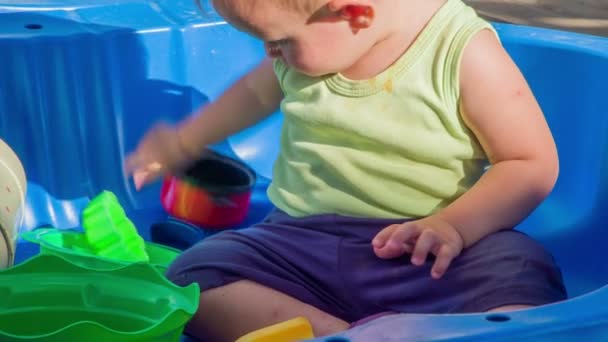 Niedliches Kleines Mädchen Spielt Draußen Verschiebt Plastikspielzeug Und Genießt Die — Stockvideo