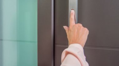 Mağazadaki lüks kapıyı test eden kadının yakın çekim görüntüleri.