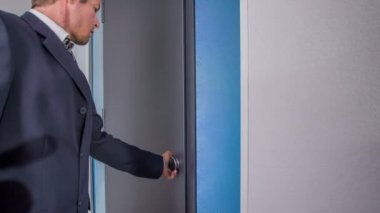 Bir adam kapıyı içeriden açıyor. Sonra içeri girdi ve dışarı çıktı..