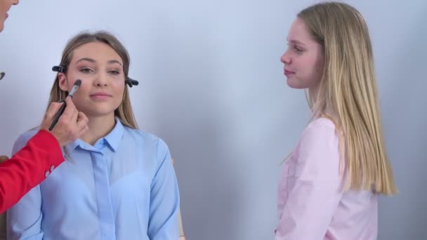 Maquillador Aplica Maquillaje Cara Del Cliente Otra Chica Queda Ahí — Vídeo de stock