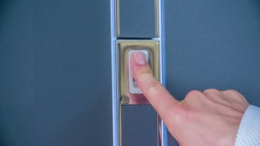 Dükkandaki lüks kapıyı test eden adamın yakın çekim görüntüleri.