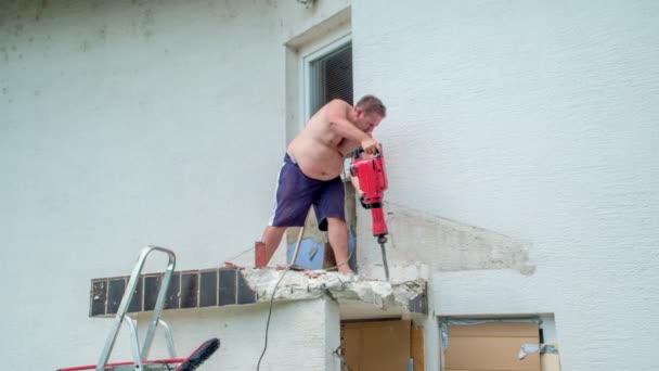 젊은이가 콘크리트 망치로 지붕을 절단하는 콘크리트를 파괴하는 — 비디오