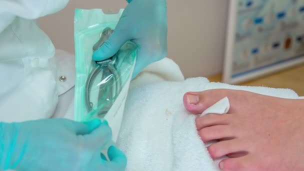 Pedicurista Sacando Cortauñas Una Pequeña Bolsa Plástico Estéril Lentamente Corta — Vídeos de Stock