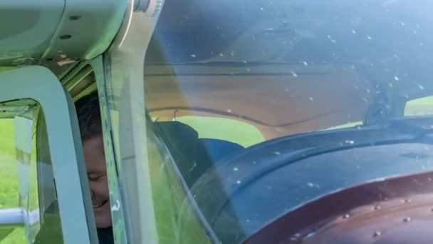 一个男人打开一架小飞机的门 向摄像机挥手 飞机即将在城镇附近行驶一小段路 — 图库视频影像